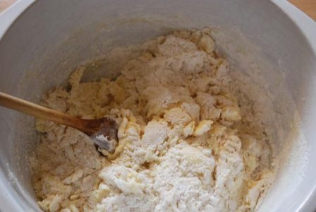 white bowl with partially mixed dough with chunks of dough and dry flour separated and&hellip;